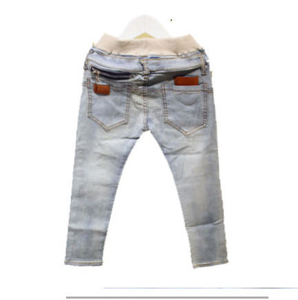 Blue jeans with zippers and buttons, standing on a wooden floor.